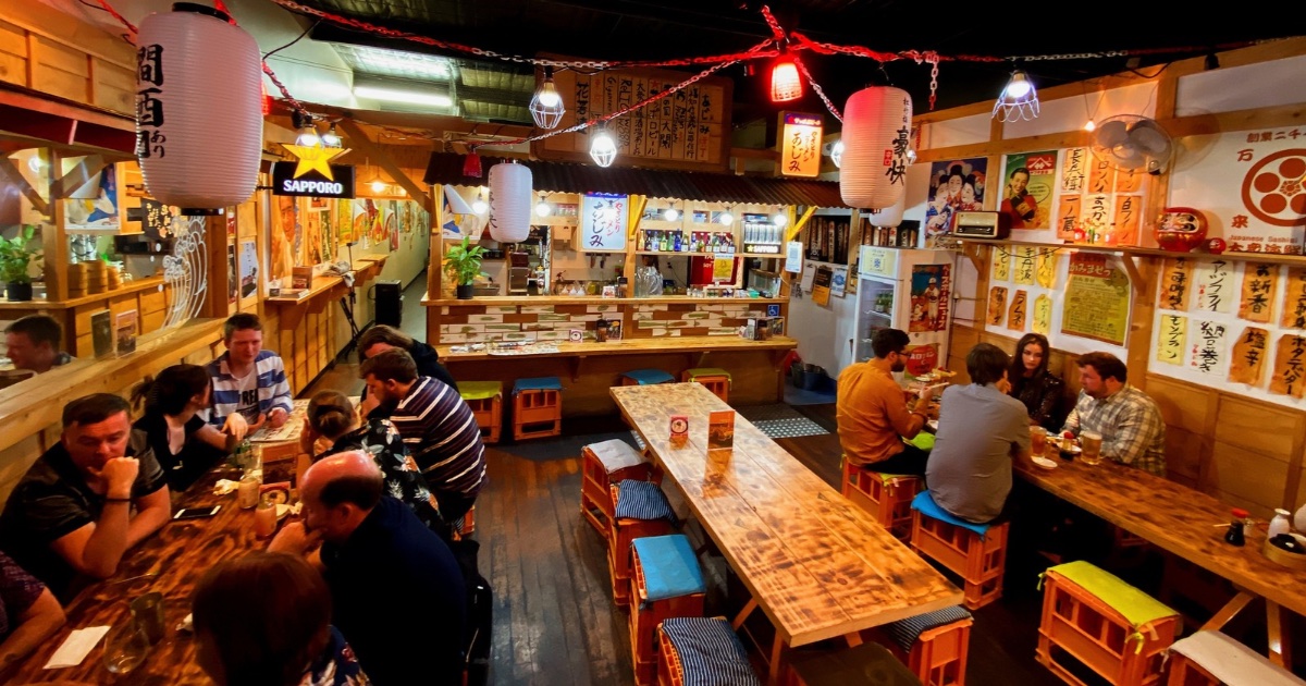 Guests enjoying the lively dining room at Japanese Sashimi Bar AJIMI